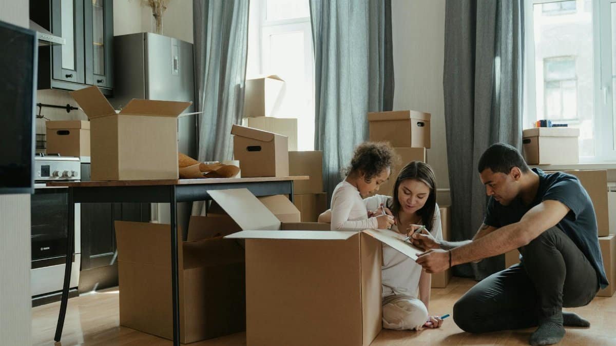 A family unpacks moving boxes in their new home kitchen, creating a cozy atmosphere.
