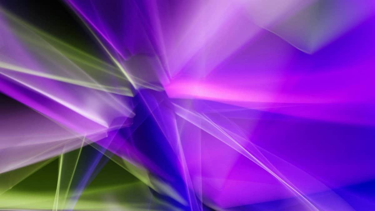 Dynamic abstract image with vibrant purple and green light streaks on a dark background.
