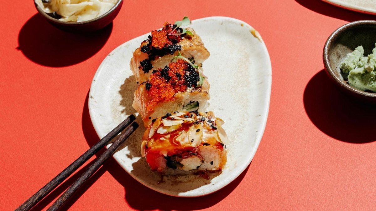 Vibrant sushi rolls on a plate with wasabi and chopsticks, perfect for Asian cuisine concepts.