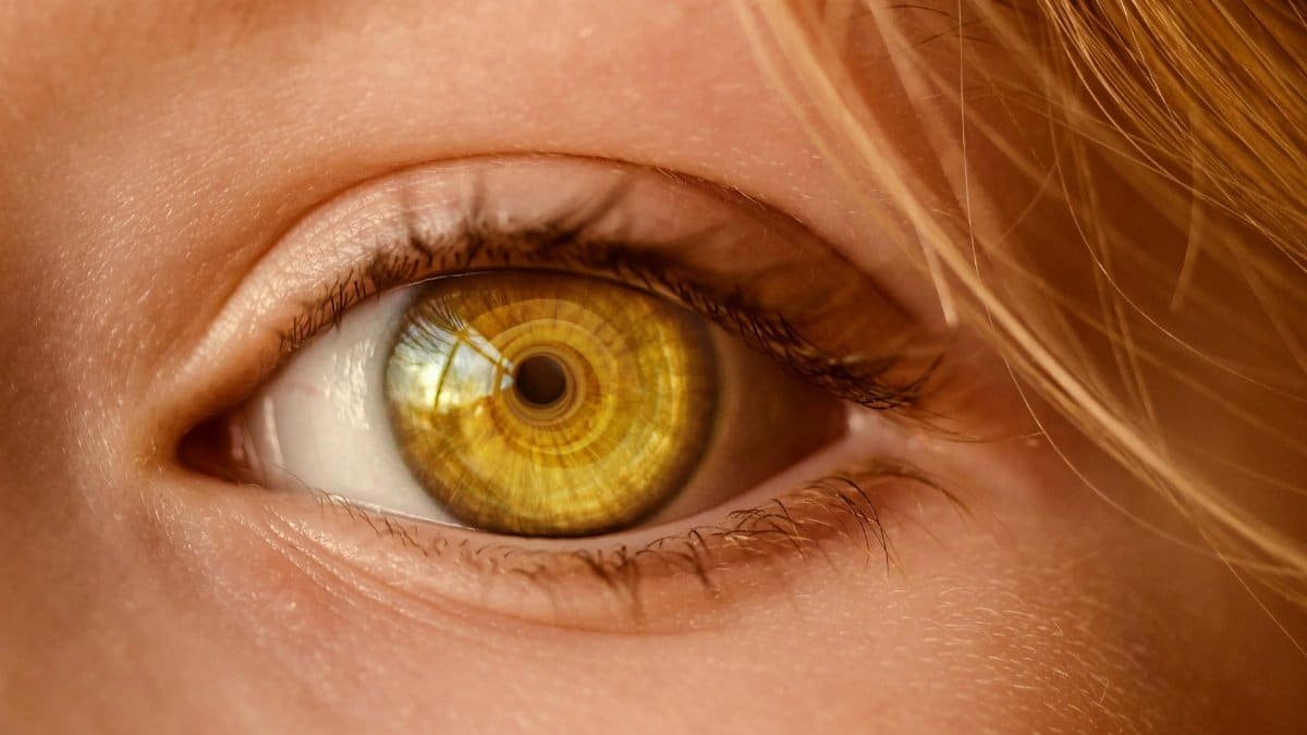 Detailed close-up of a human eye with a unique golden iris and spiral light reflection.