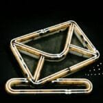 A glowing neon envelope symbol against a black background, conveying messaging or email concept.