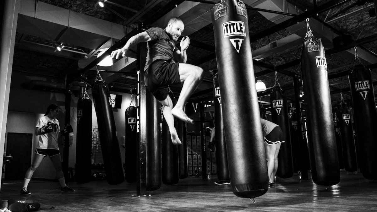 Action-packed scene of a man training in a gym with punching bags.