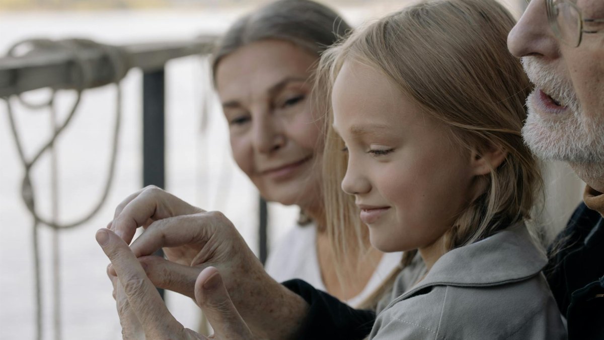 A joyful moment with grandparents and granddaughter sharing time together outdoors.