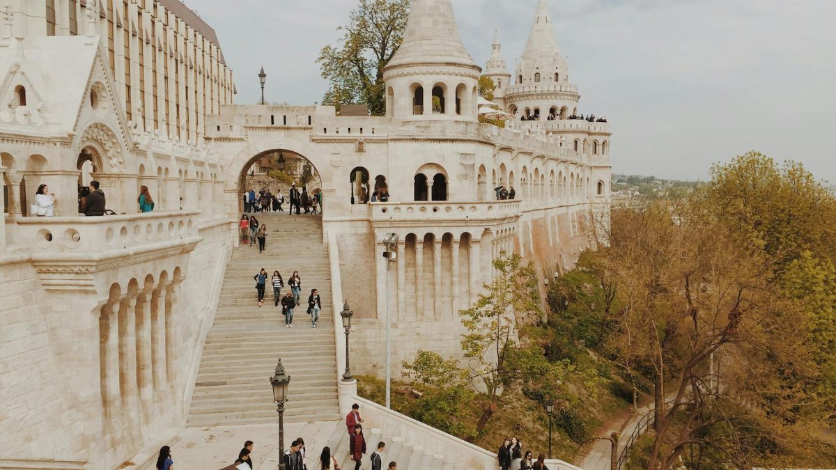 Tourists exploring the historic Fisherman's Bastion in Budapest, Hungary on a beautiful day.