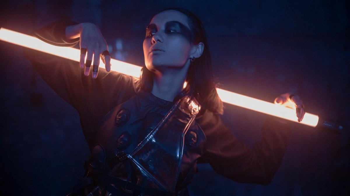 Striking portrait of a woman in cyberpunk fashion, illuminated by neon light.
