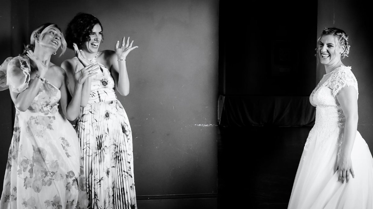 A candid black and white photo capturing a joyful moment between bridesmaids and the bride.