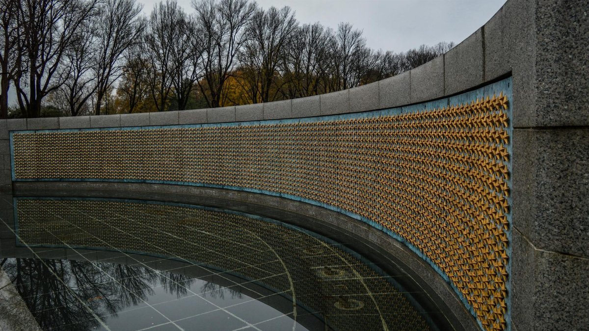 Golden stars on Freedom Wall at World War II Memorial located in in National Mall in Washington DC against gloomy sky