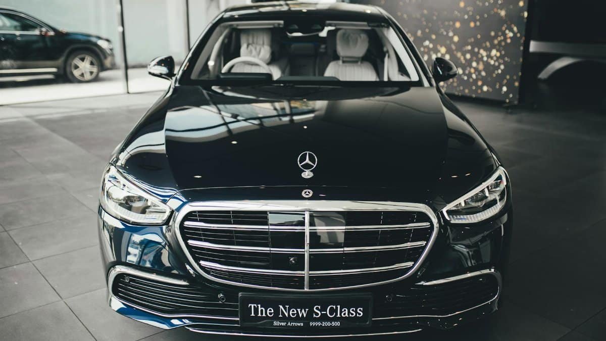Front view of a luxury Mercedes-Benz S-Class on display in a New Delhi showroom.