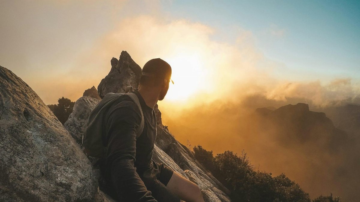 Man enjoying a breathtaking mountain sunset in Waikato, New Zealand, showcasing outdoor adventure and natural beauty.
