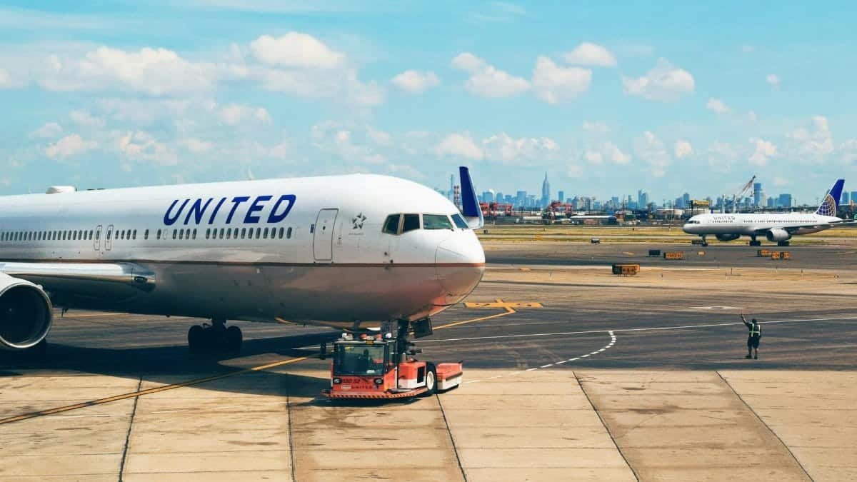 Aircraft on the runway at Newark Airport with city skyline in the background.