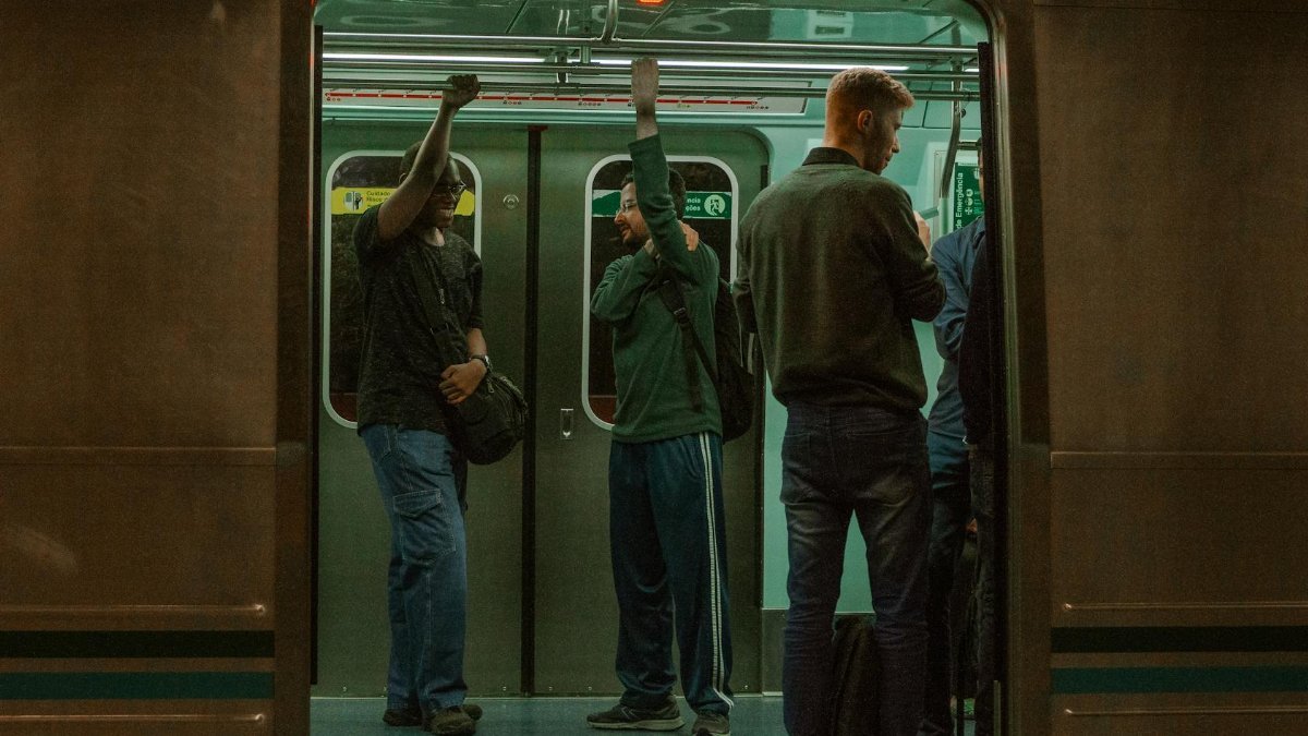 A group of people commuting on a subway train, showcasing urban public transportation.