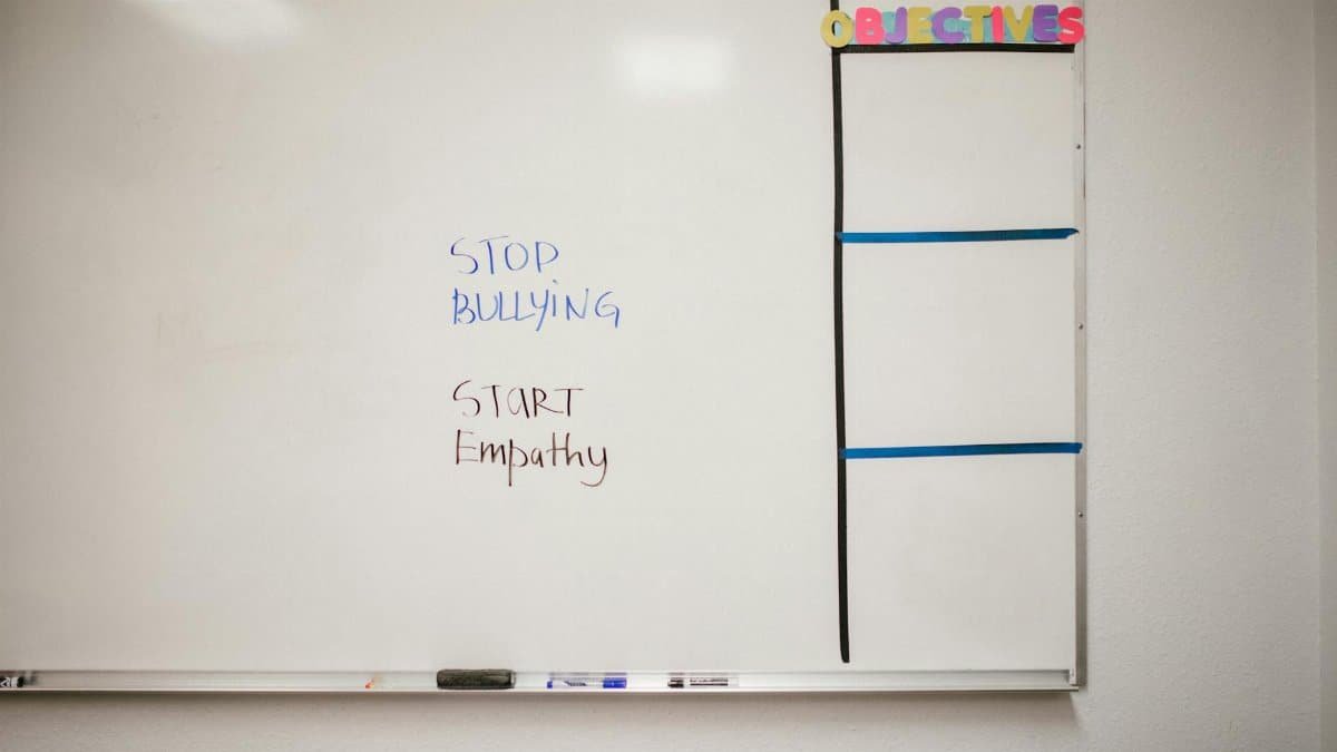 Whiteboard with messages to stop bullying and start empathy for school awareness.