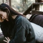 A troubled couple sits outdoors during a deeply emotional conversation.