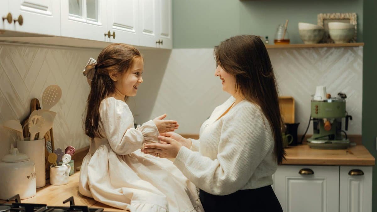 A warm mother-daughter moment captured in a vintage kitchen setting.