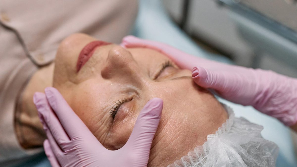 A serene spa therapy session with a senior woman enjoying a facial massage for rejuvenation.