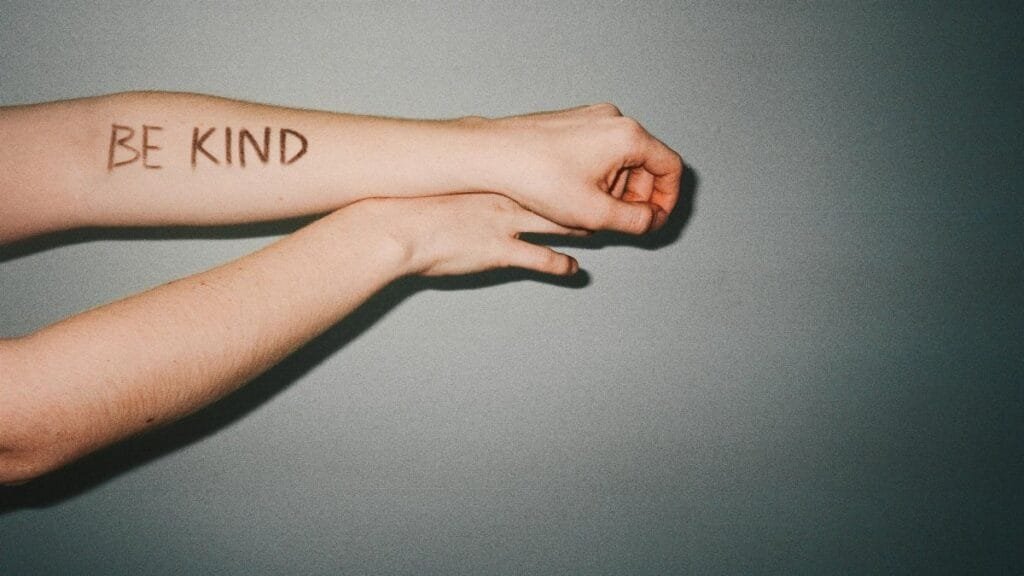 Arm with 'Be Kind' message written in bold letters conveying a positive reminder.