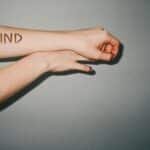 Arm with 'Be Kind' message written in bold letters conveying a positive reminder.