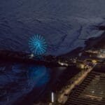 Stunning aerial view of Atlantic City at night featuring an illuminated Ferris wheel by the coast.