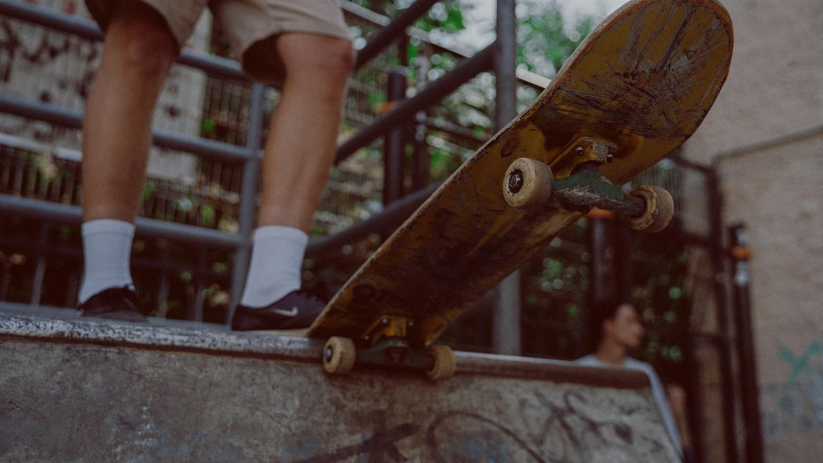 A skateboarder standing on a ramp with graffiti, ready to skate.