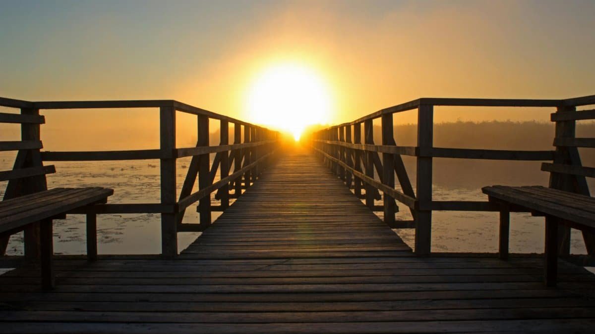 A breathtaking sunrise over a wooden pier, perfect for relaxation and reflection by the water.