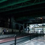People walking under an urban overpass in Nagawa, Japan, showcasing daily commuting life.