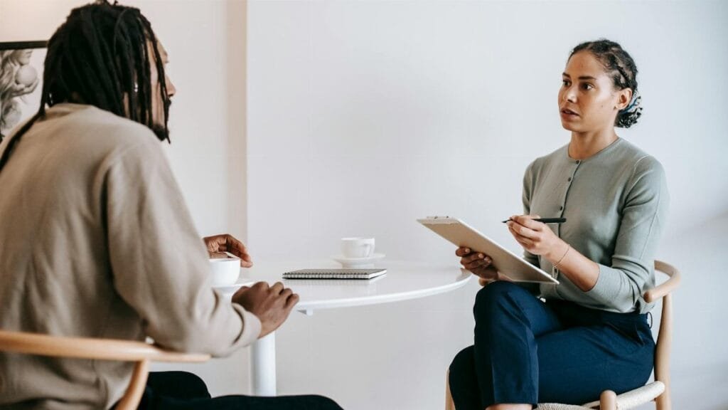 A professional job interview between a man and woman in a modern office setting.