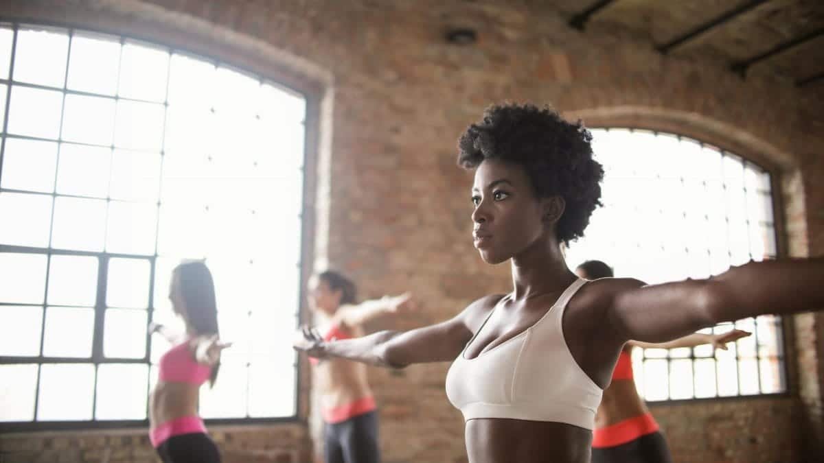 Diverse group of people exercising in an industrial-style loft with brick walls.