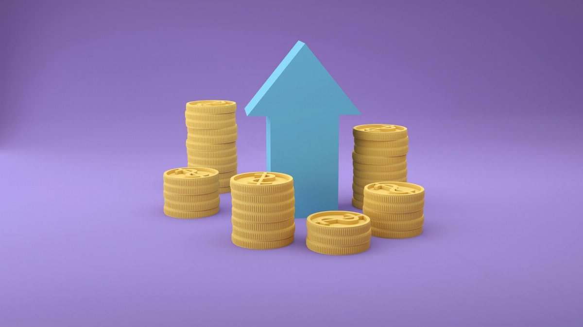 Stacks of coins with an upward arrow symbolizing financial growth and success.
