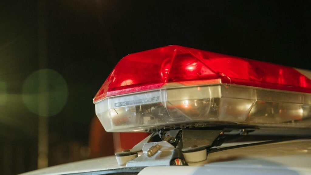 Detailed view of a police car's red siren light shining at night.