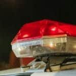 Detailed view of a police car's red siren light shining at night.