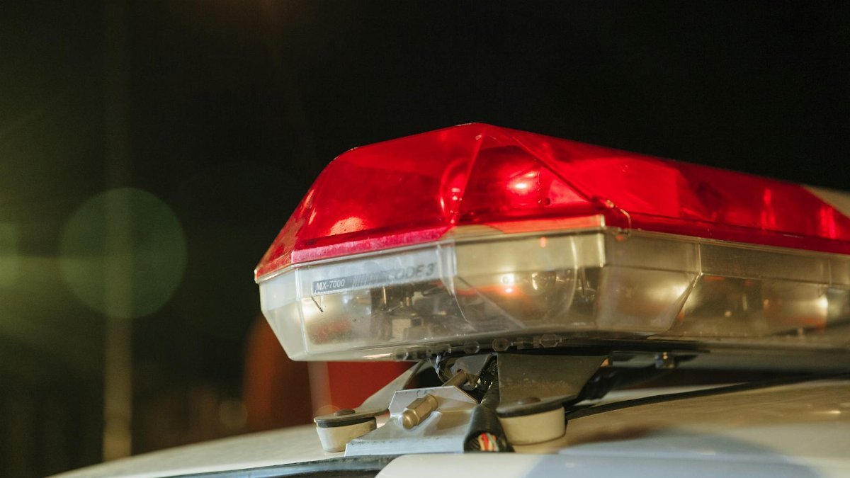 Detailed view of a police car's red siren light shining at night.