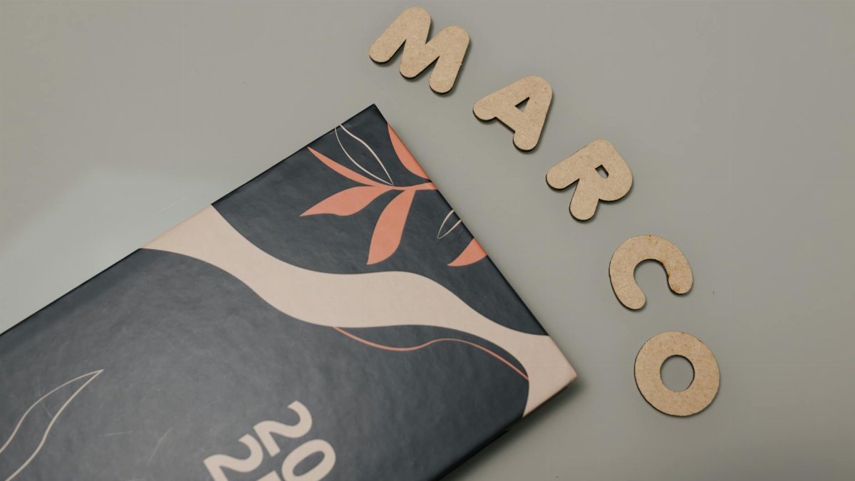 Creative flat lay of a 2025 notebook and cutout letters on a beige surface, perfect for organization visuals.