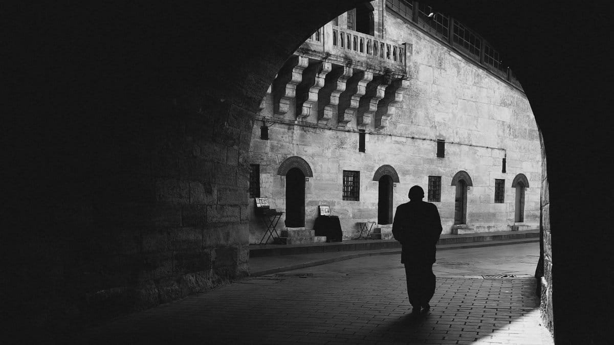 Black and white silhouette of a person walking through an archway in Istanbul.