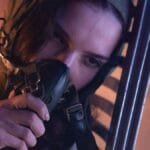 An astronaut in a space suit resting indoors, showcasing fatigue and futuristic themes.