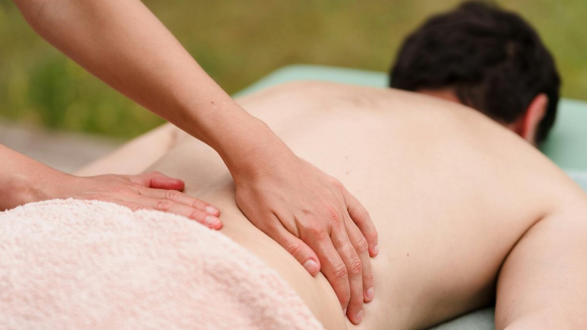Close-up of hands performing a relaxing massage outdoors. Ideal for wellness and relaxation themes.