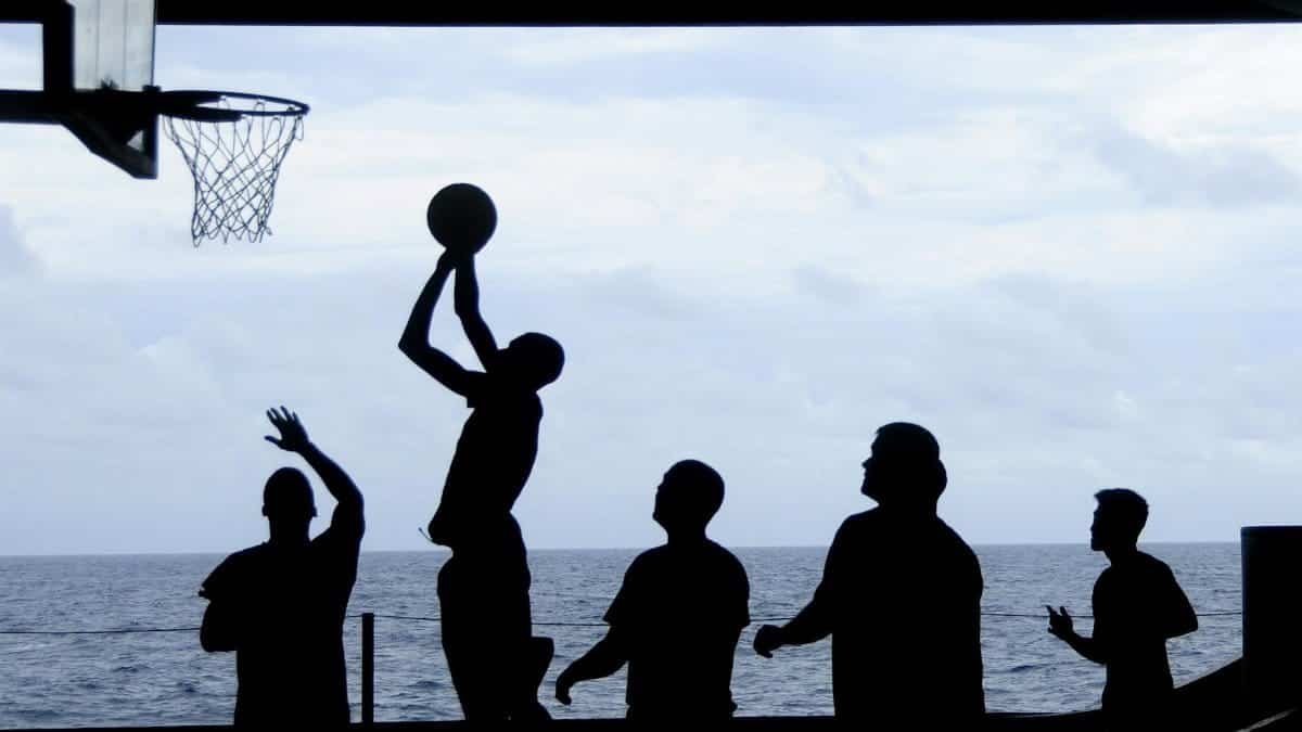 Silhouette of a basketball game played by the ocean, creating a striking visual scene.