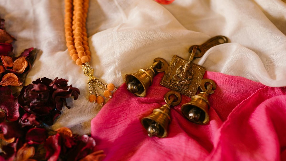 Colorful arrangement of Ganesha bells, beads, and petals symbolizing Indian festivals and traditions.