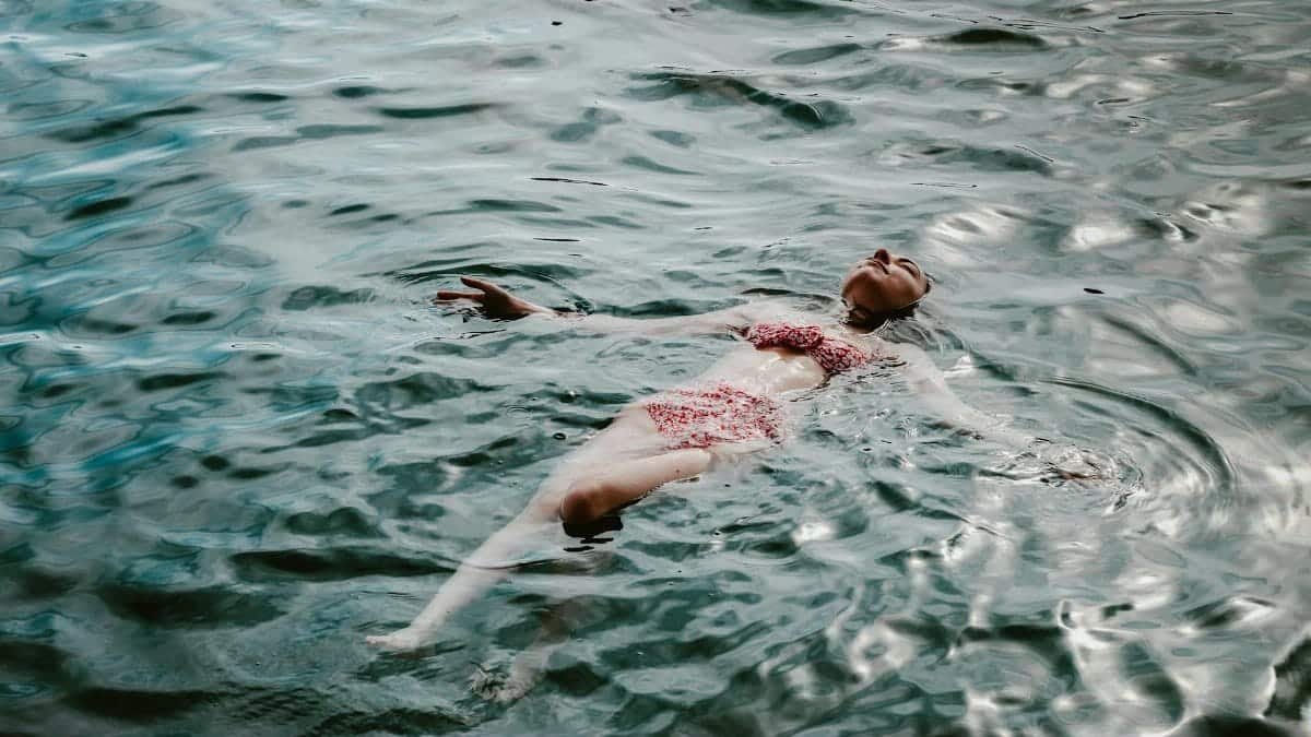 A woman relaxes in a bikini, floating in a serene lake in Muğla, Türkiye.
