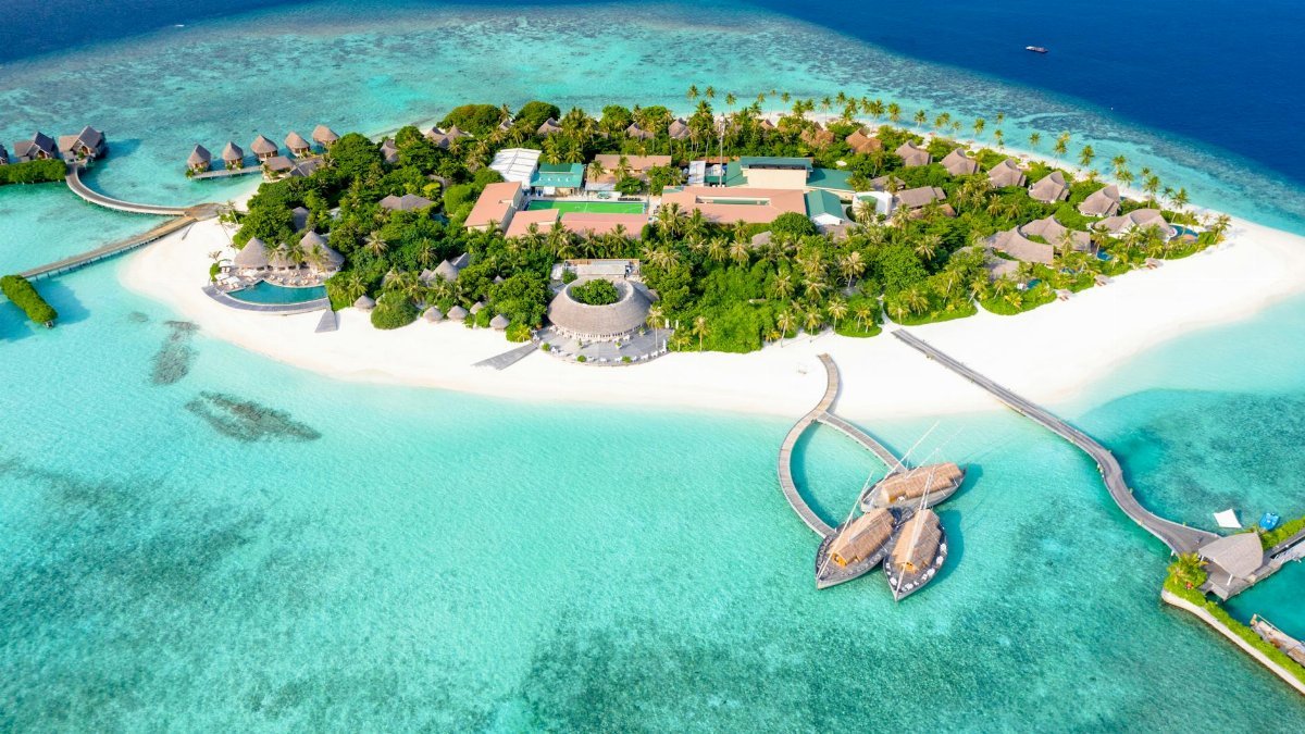 Aerial view of a serene tropical island resort surrounded by crystal-clear waters.