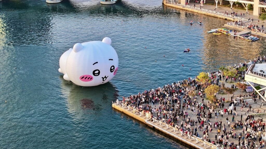 Crowds gather by the waterfront to see a giant inflatable bear.