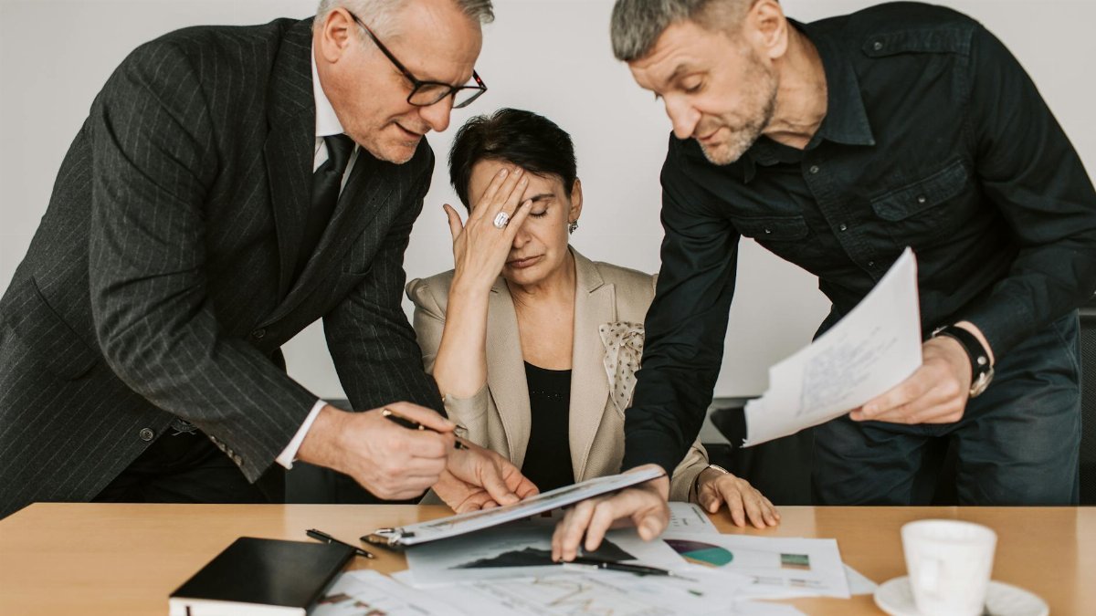 A professional team in a tense business meeting discussing financial documents.