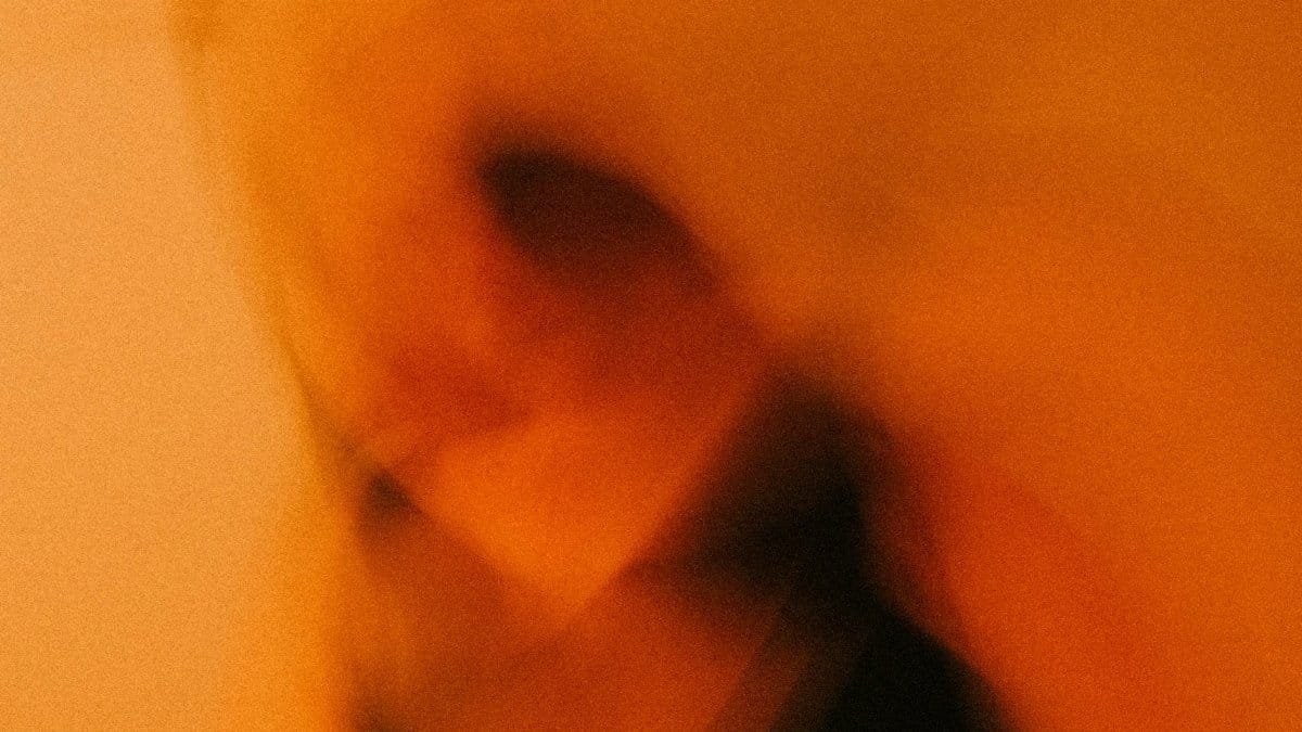 Dynamic blurred image with warm orange tones and abstract motion effects.