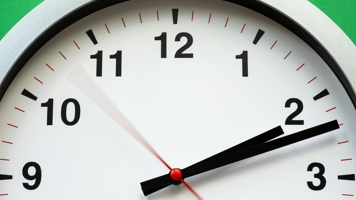 A close-up image of an analog clock face showing time with blurred motion