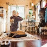A person meditates in a cozy wooden cabin with mountain views in Colorado.