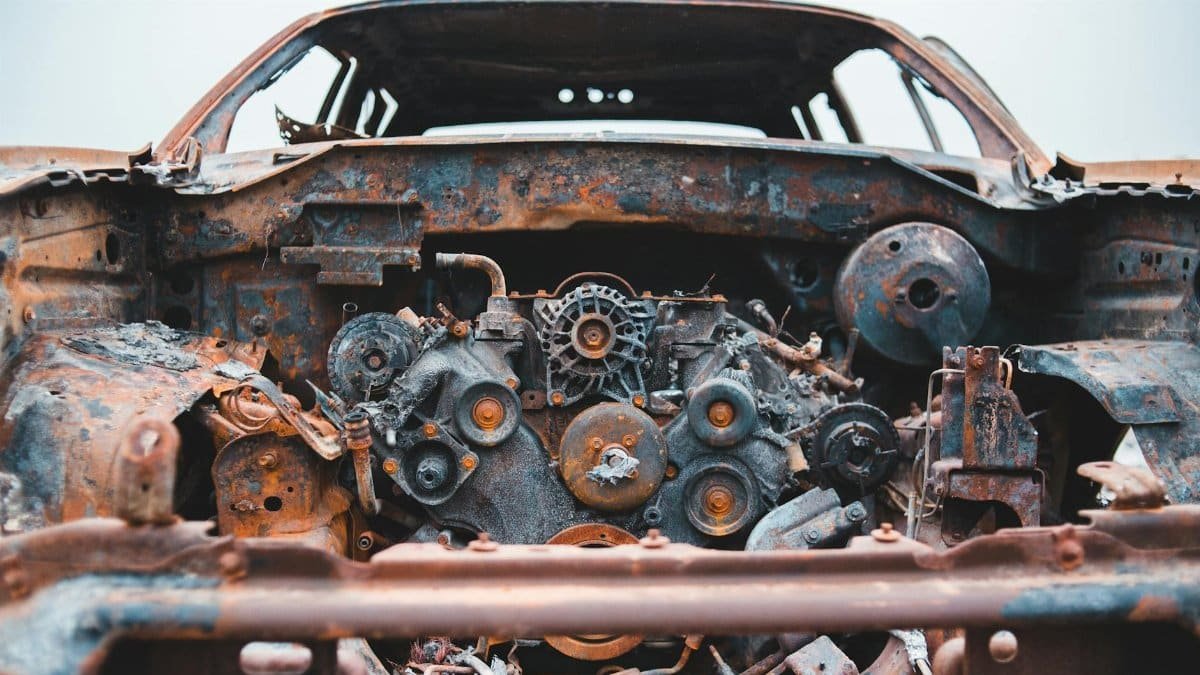 Detailed shot of a rusty, abandoned car engine, showcasing decay and neglect.