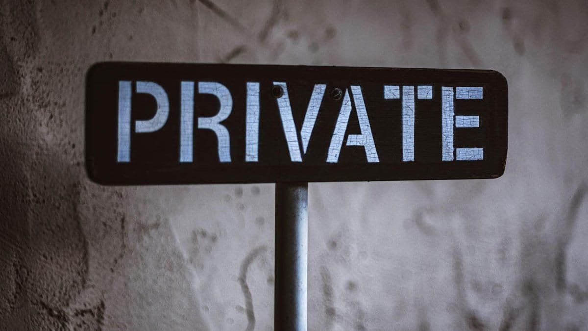 A weathered 'Private' sign on a rustic wall background in Solvang, California.
