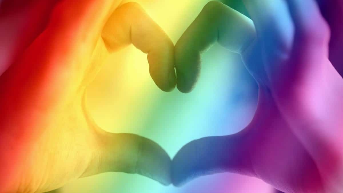 Hands forming a rainbow heart shape, symbolizing love, unity, and LGBTQ pride.