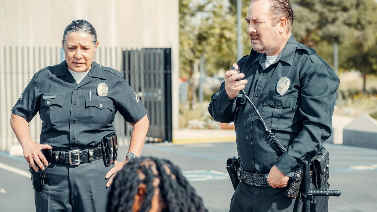 Two police officers interacting at a crime scene, focusing on communication and law enforcement duties.