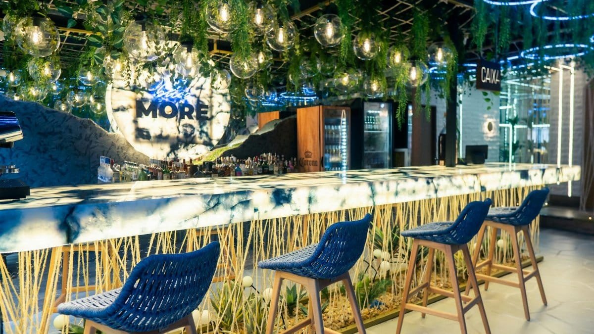 Contemporary bar interior in Rio de Janeiro with lush greenery and vibrant lighting.