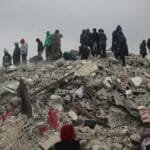 Survivors and rescuers search through rubble after a disaster in Idlib, Syria.